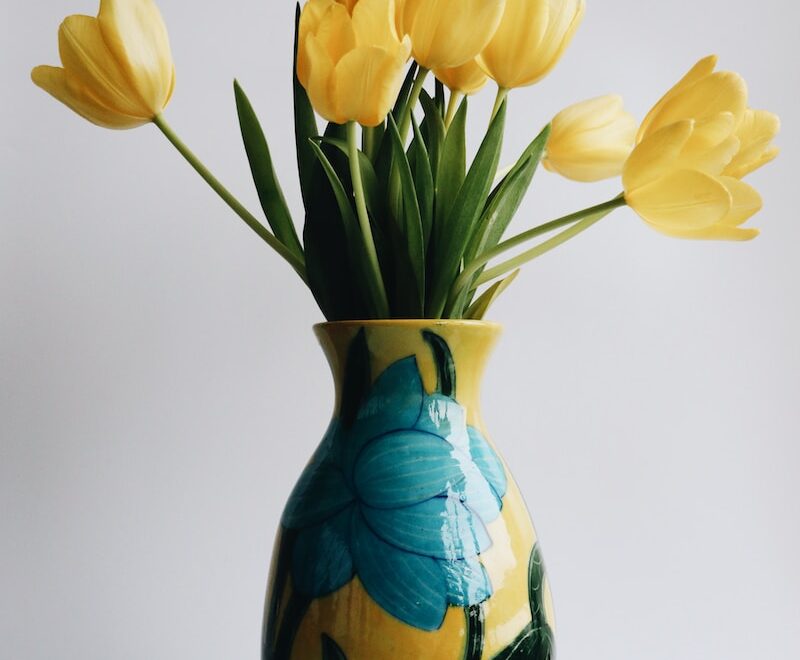 a vase filled with yellow flowers on top of a table