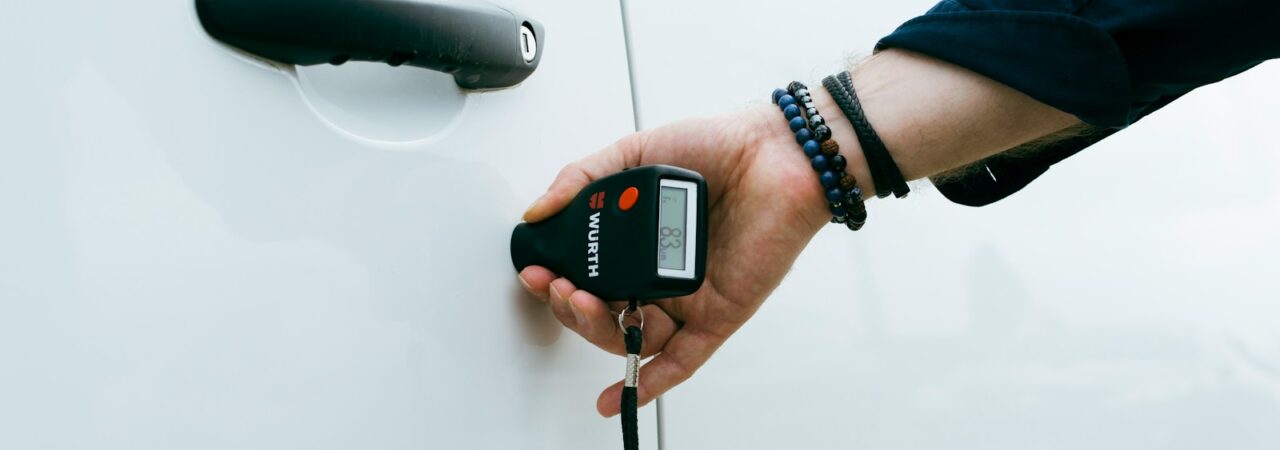 A person is holding a car door handle