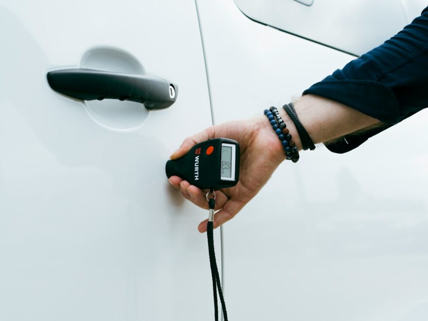 A person is holding a car door handle
