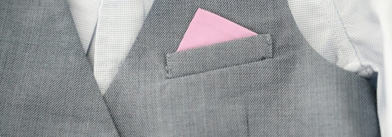 a close up of a person wearing a suit with a pink pocket