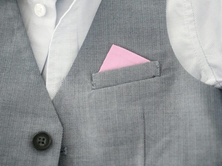 a close up of a person wearing a suit with a pink pocket